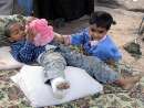 thumb for Kashmiri children play with a toy outside their tent in Muzaffarabad